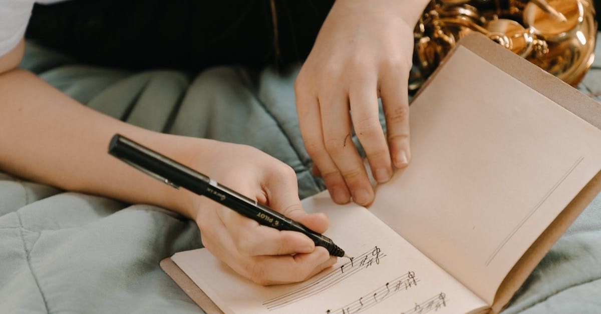 Uma pessoa está escrevendo em um caderno com uma caneta.
