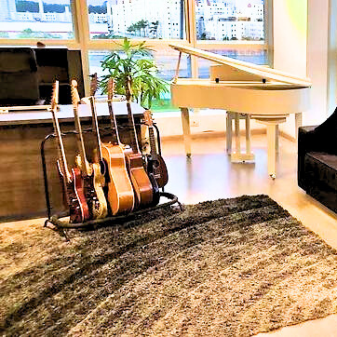 Um monte de guitarras estão em um suporte na sala de estar.