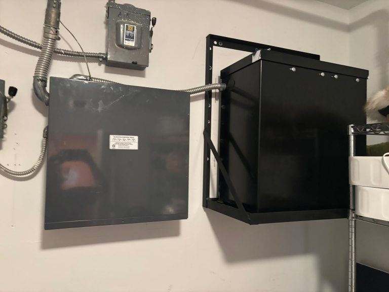 Black electrical equipment mounted on a white wall.