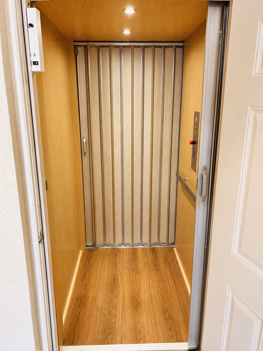 Small wooden entryway with a closed accordion door and white door frames.
