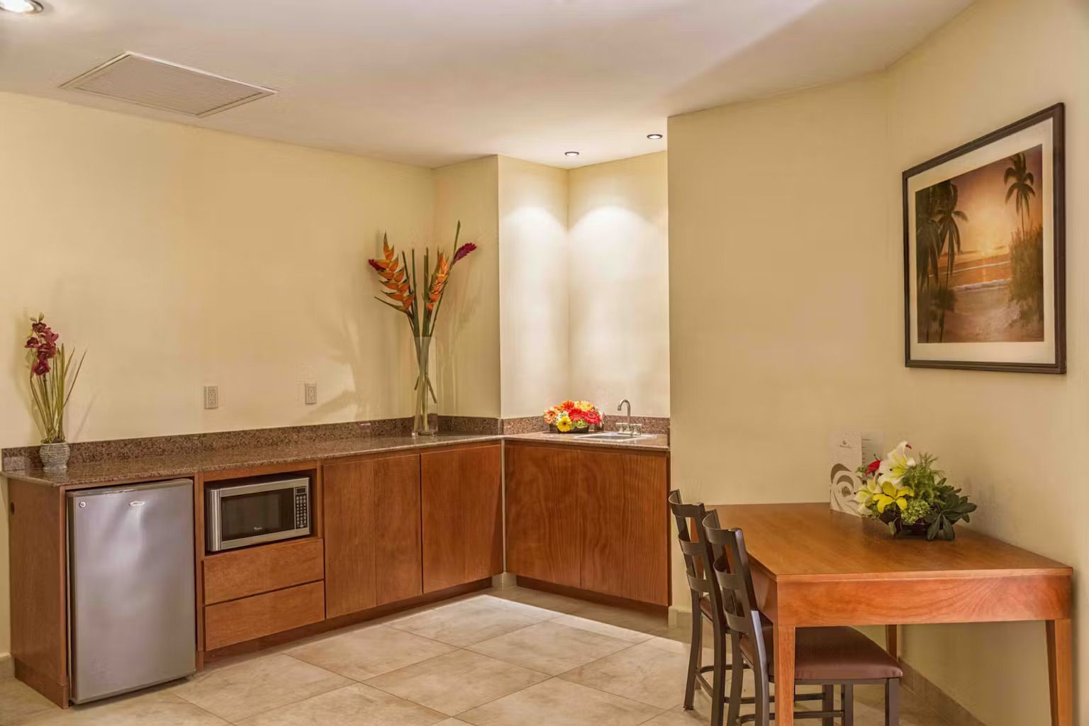 A kitchen with a table and chairs and a picture on the wall.