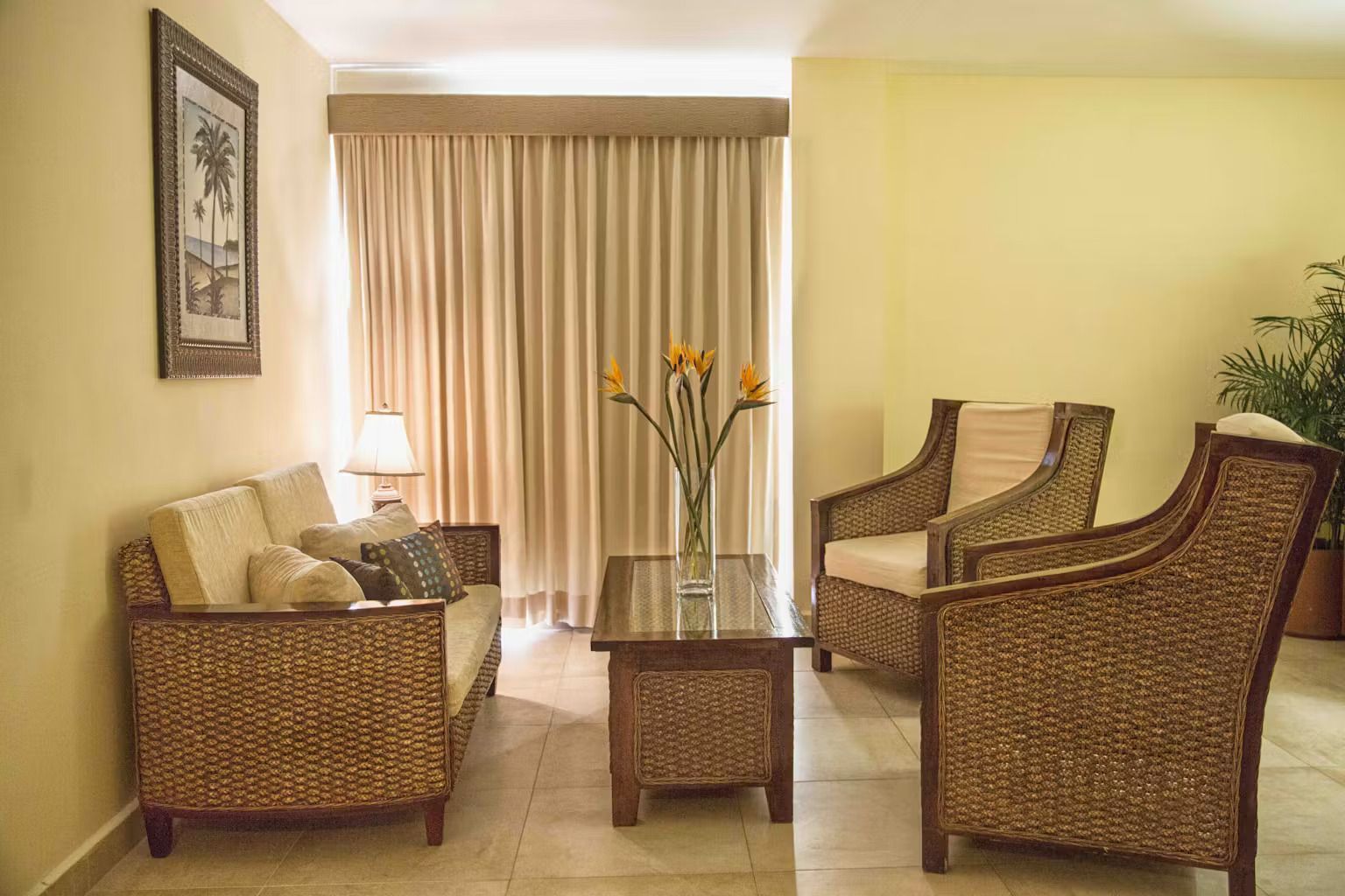 A living room with wicker furniture including a couch and chairs