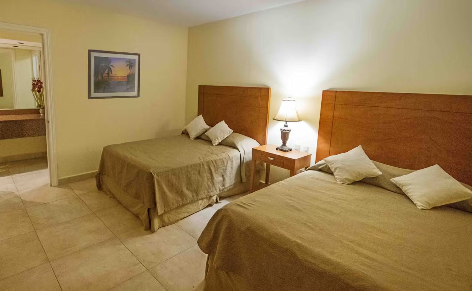 A hotel room with two beds and a bathroom.