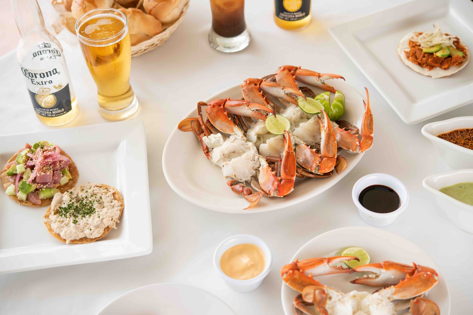 A table topped with plates of food and a glass of beer.