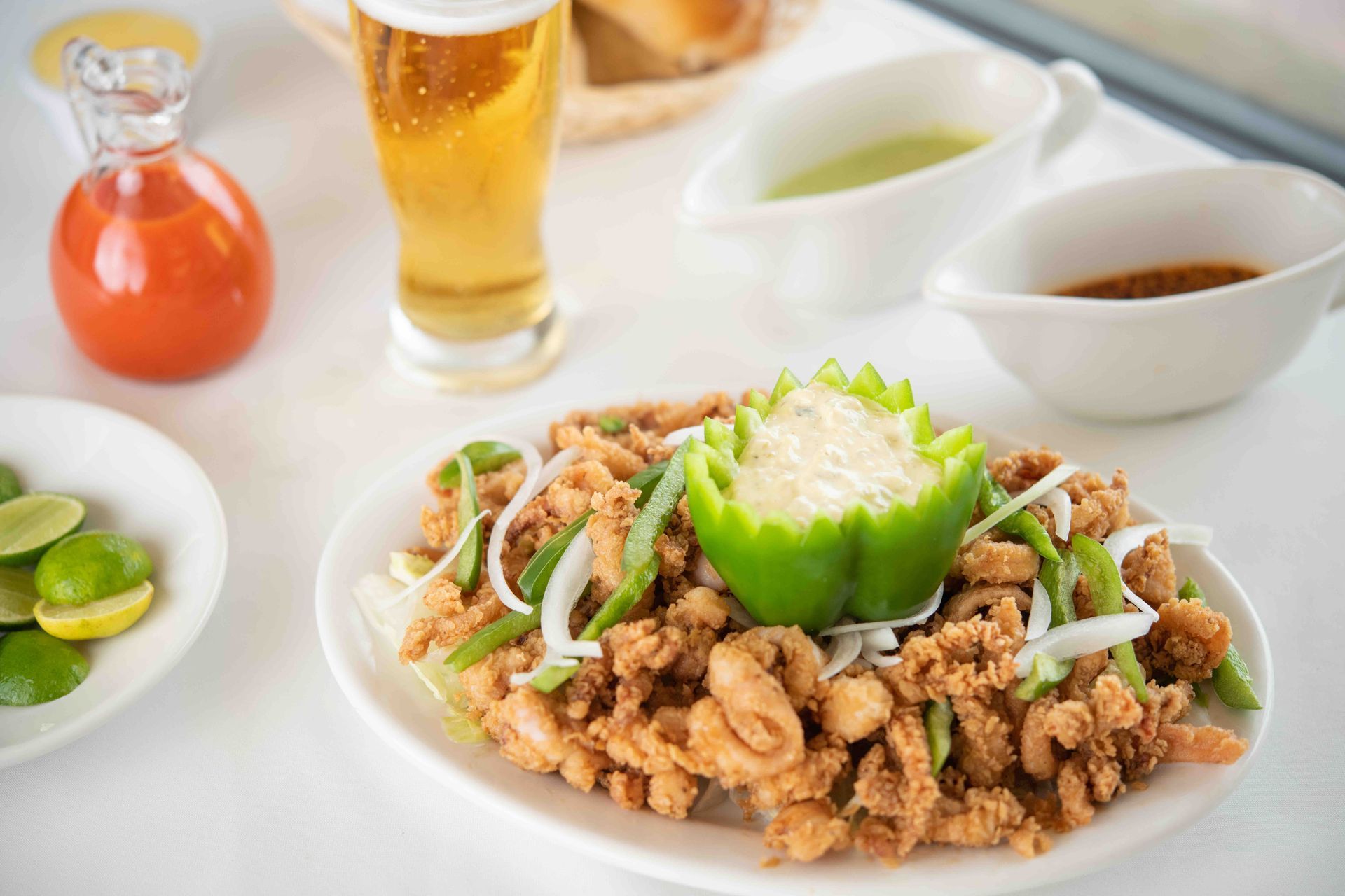 A plate of food with a glass of beer on a table.
