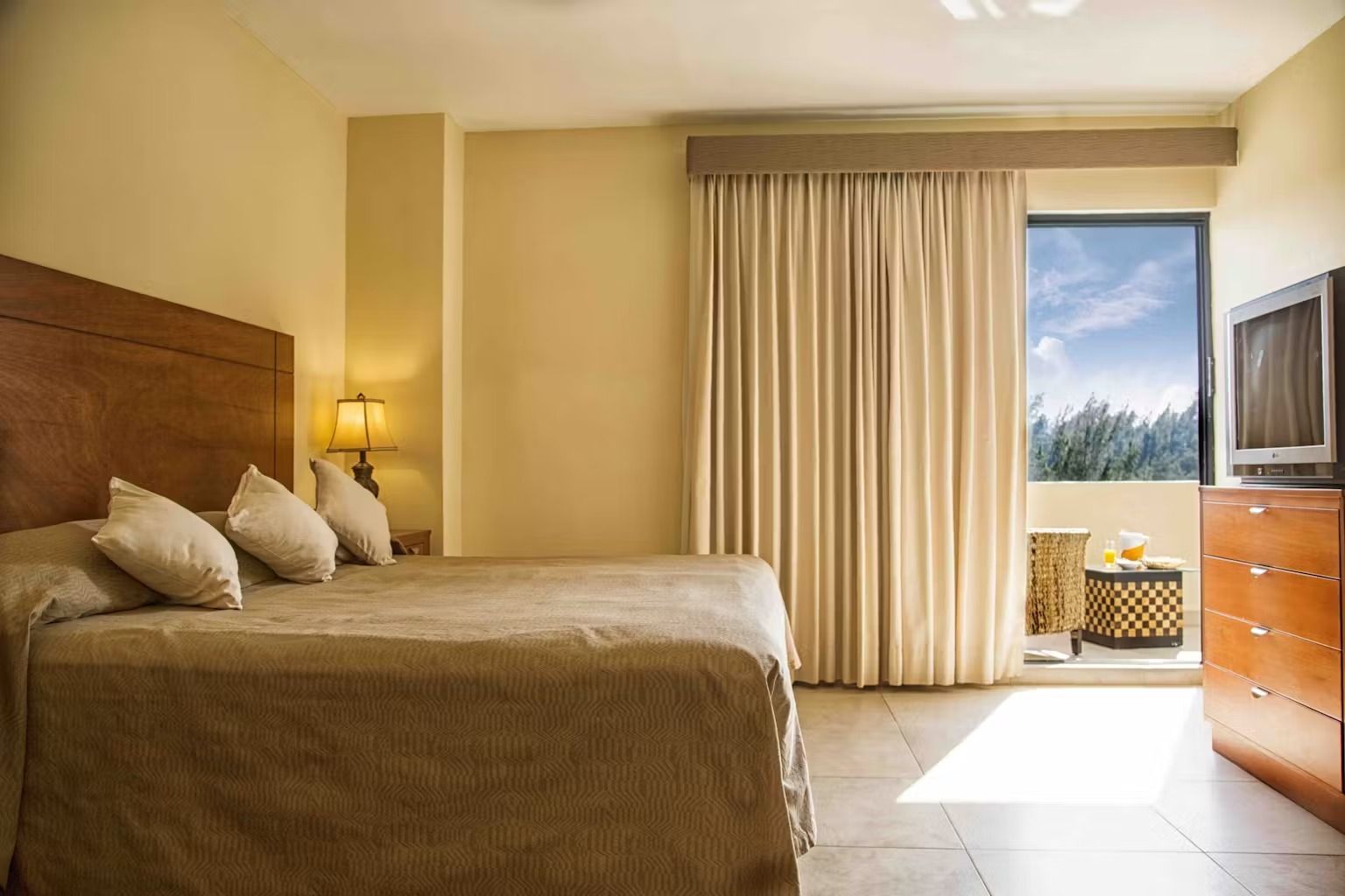 A hotel room with a large bed and a television