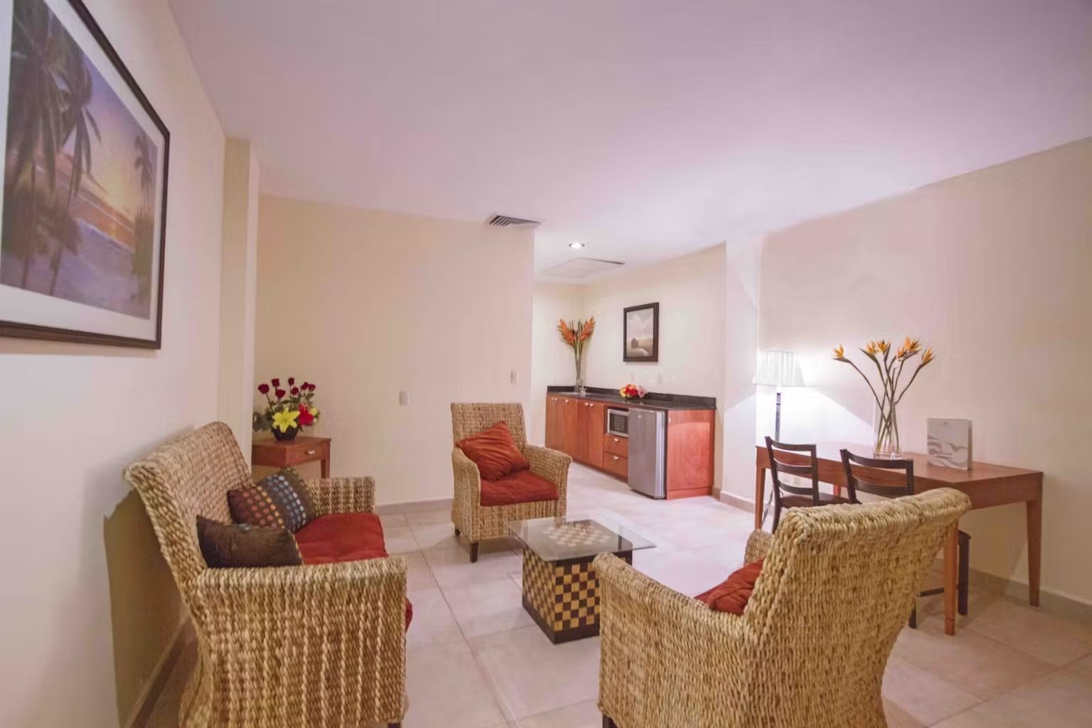 A living room with wicker furniture and a picture on the wall
