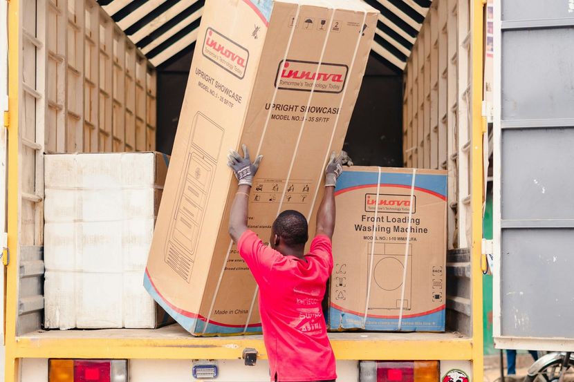 Worker loading large cardboard boxes into a truck at a warehouse loading dock Appliance Removal Sacramento