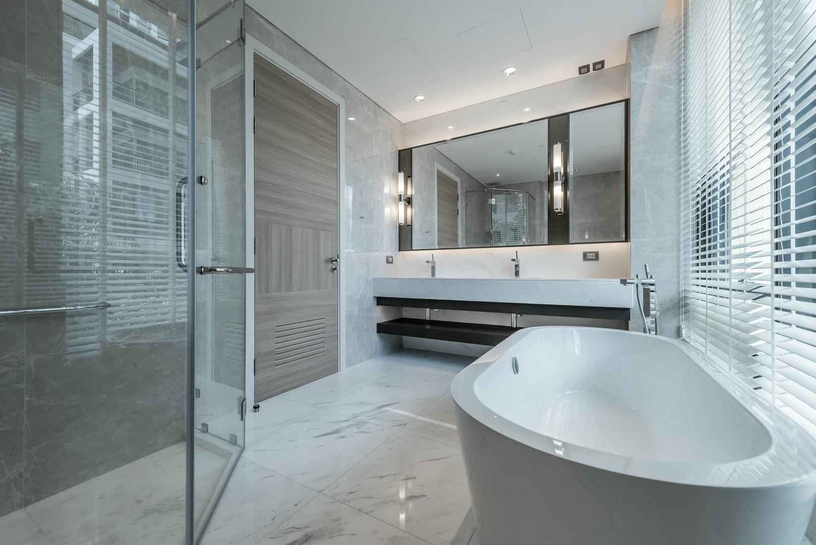 Modern bathroom with a freestanding tub, glass shower, and double vanity.