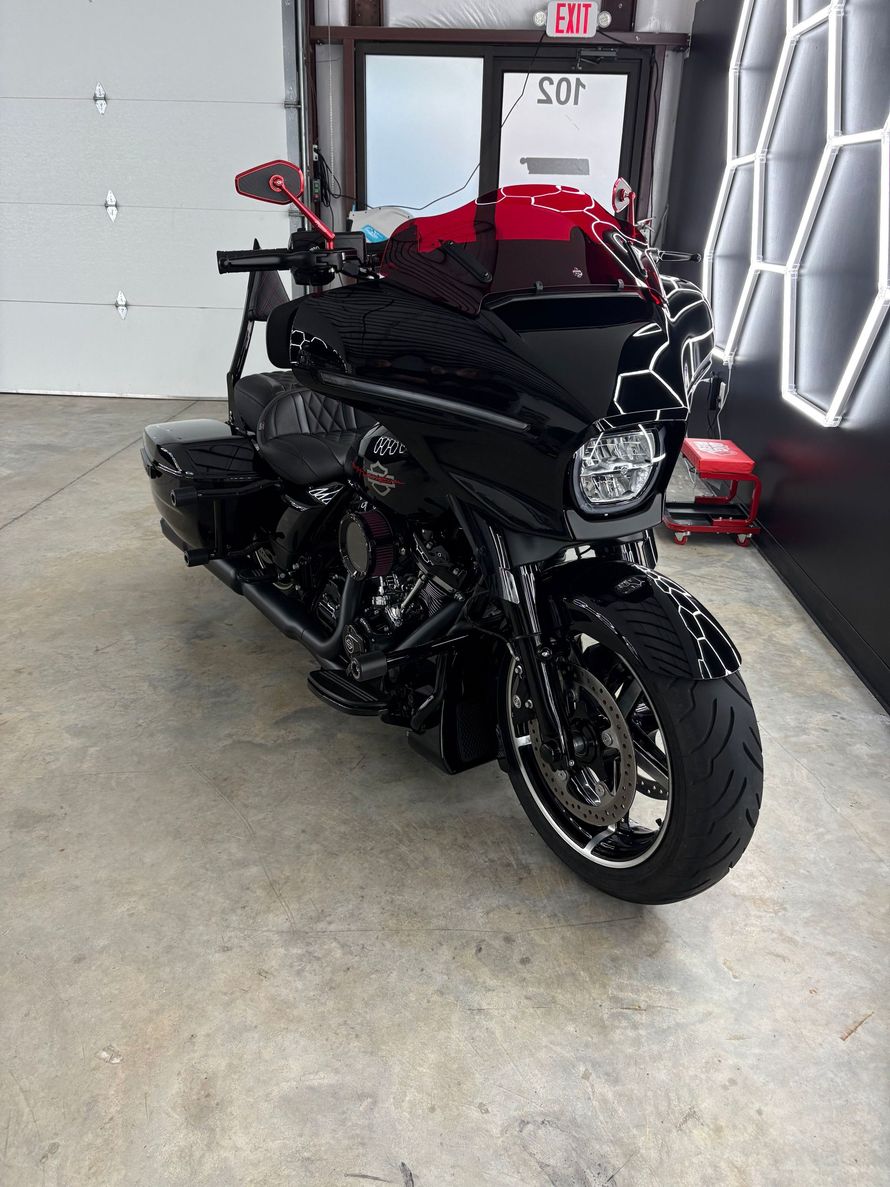 Black motorcycle parked indoors in a garage, facing forward.