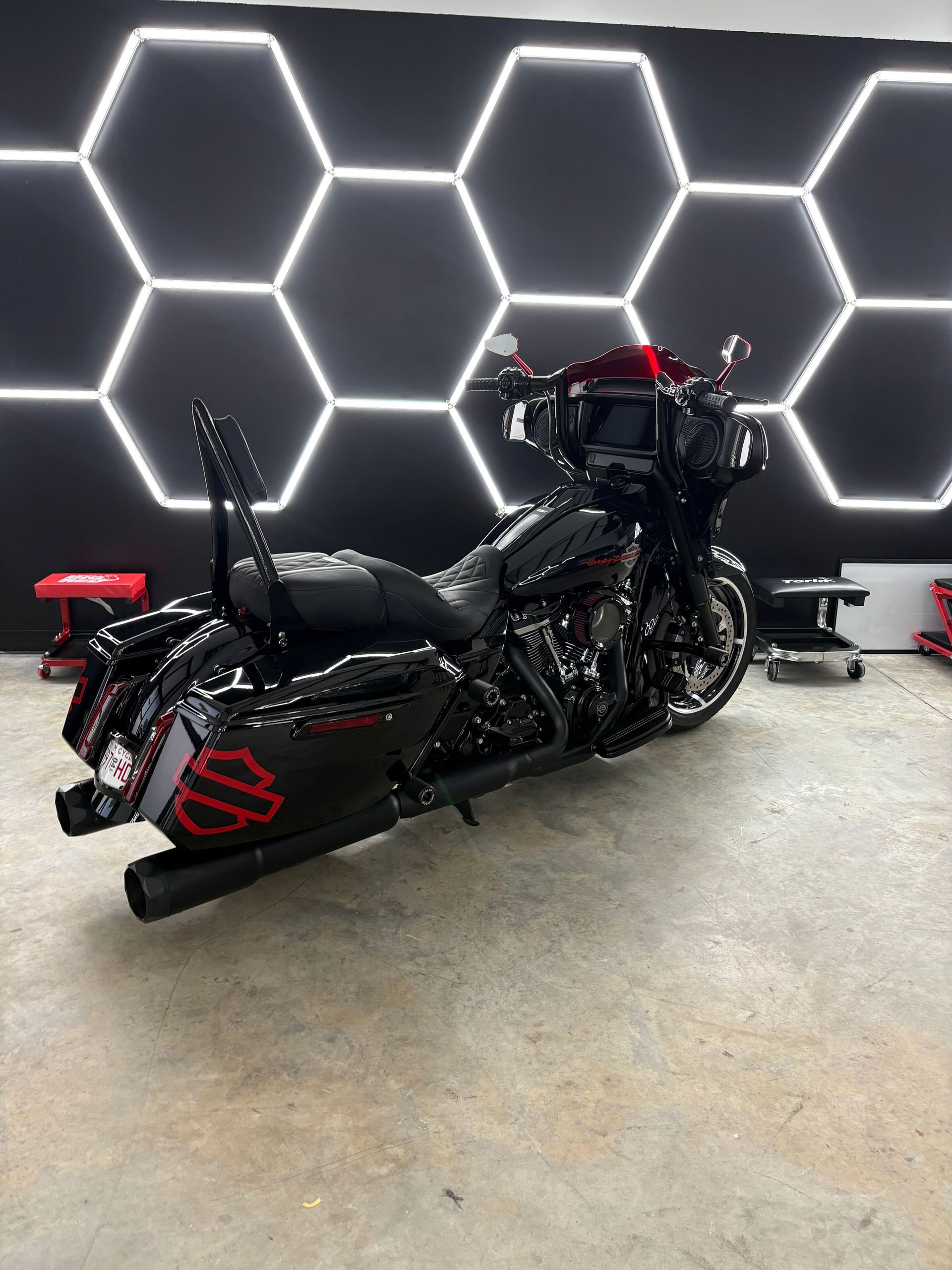 Black custom motorcycle in a garage with hexagonal LED wall lights