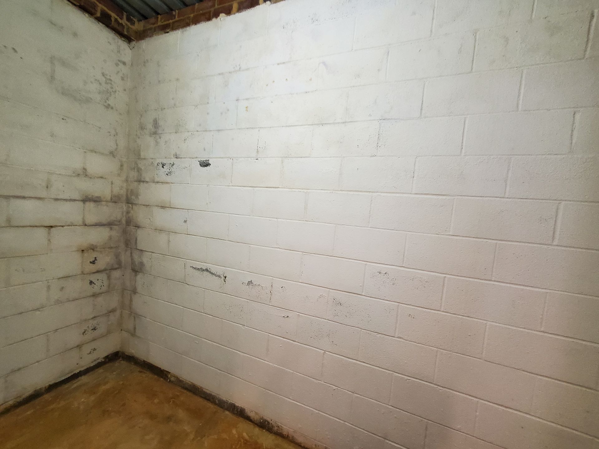 a room with white brick walls and a brown floor