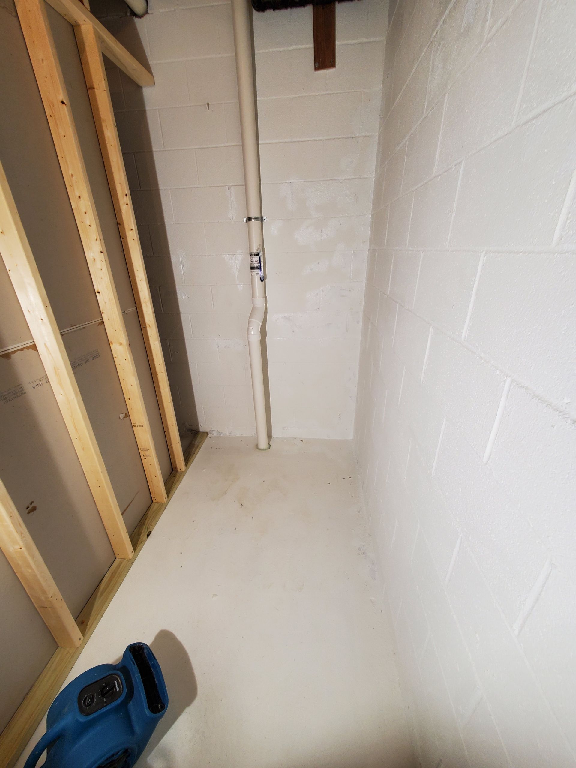 a room with white walls and a blue bag on the floor