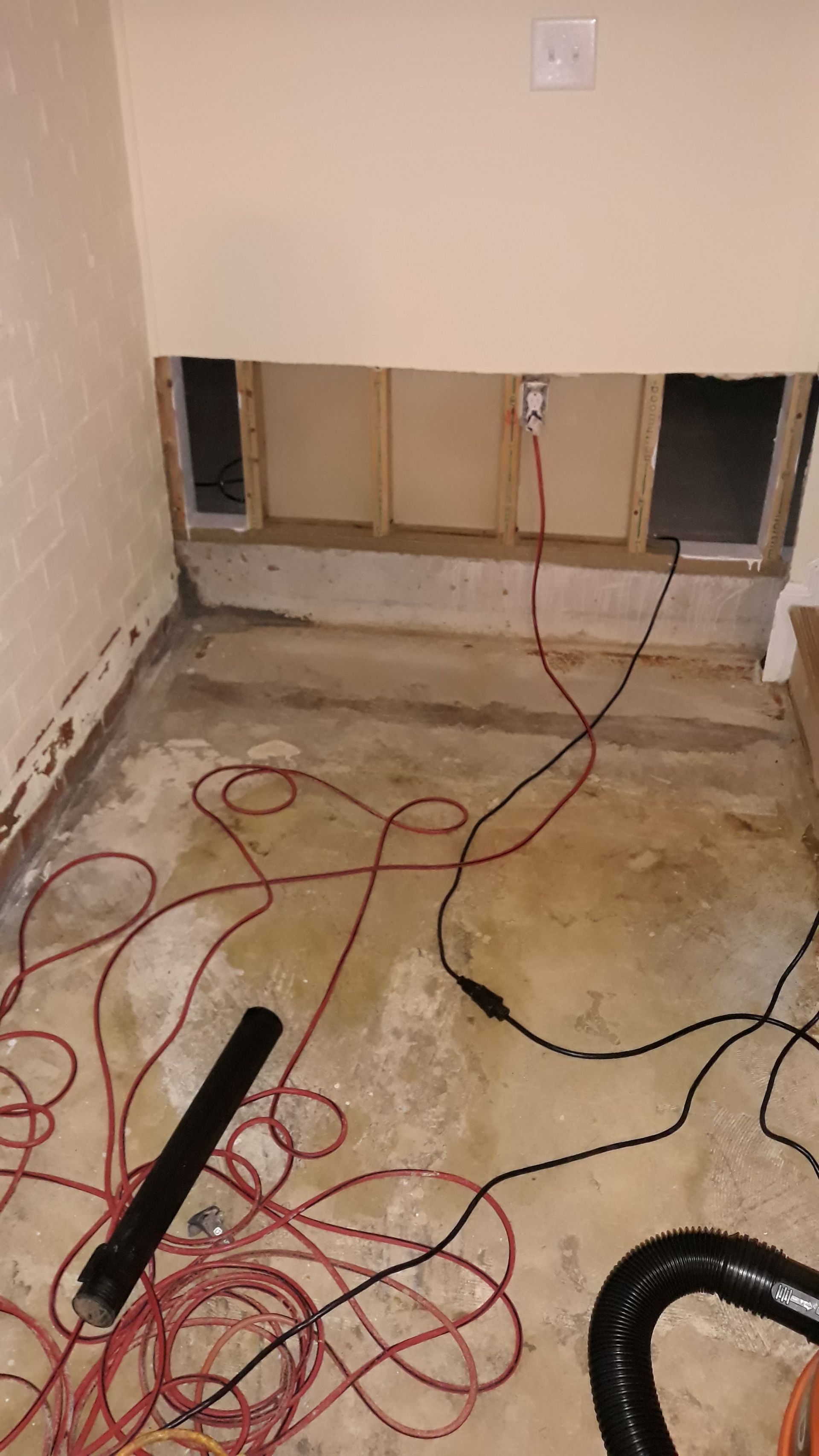 a room with a hole in the wall and a vacuum cleaner on the floor