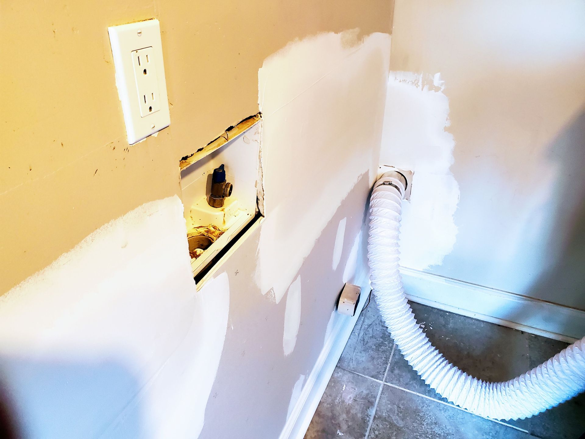 a white hose is attached to a wall in a room
