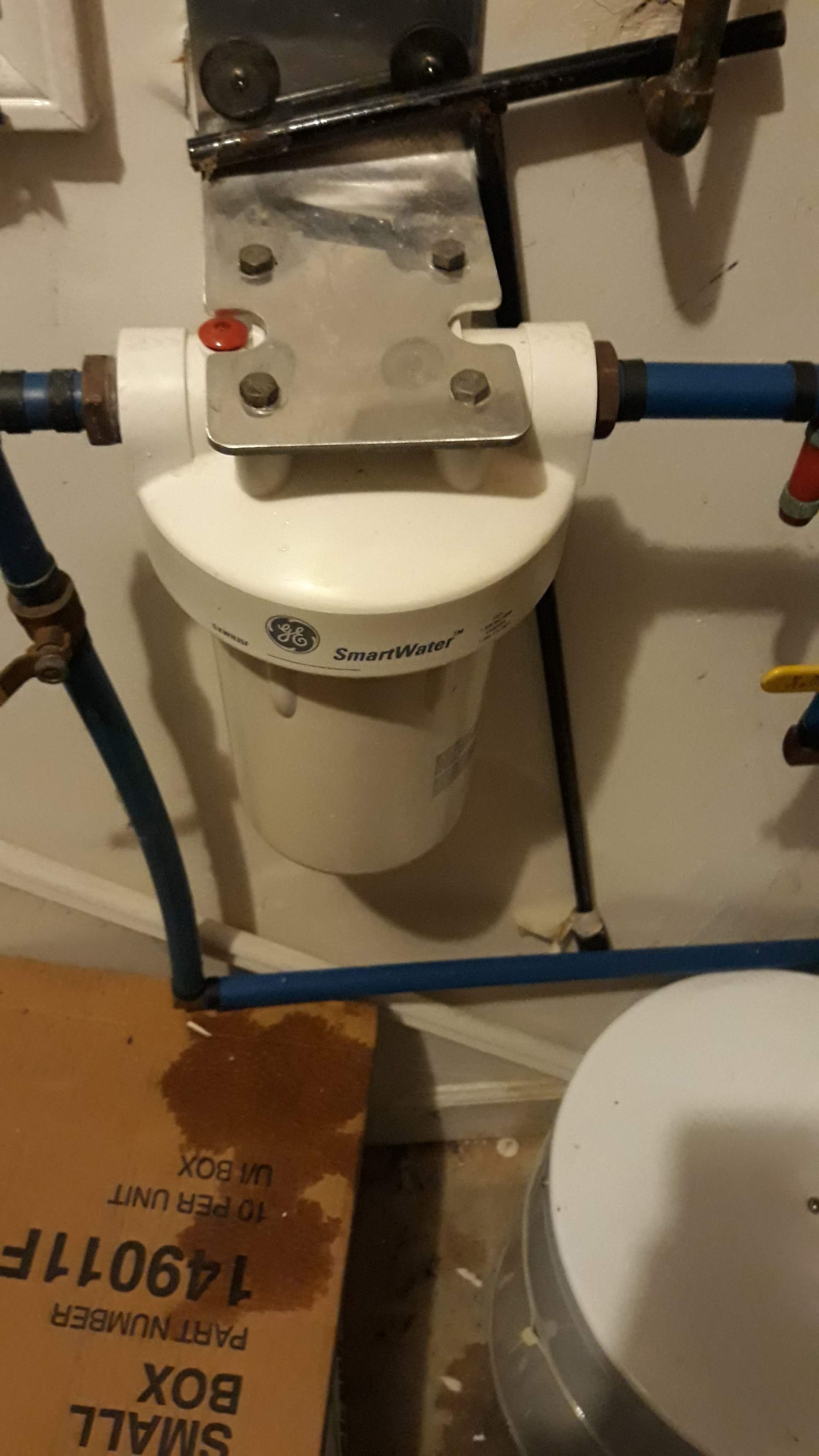 a water filter is hanging on a wall next to a small box
