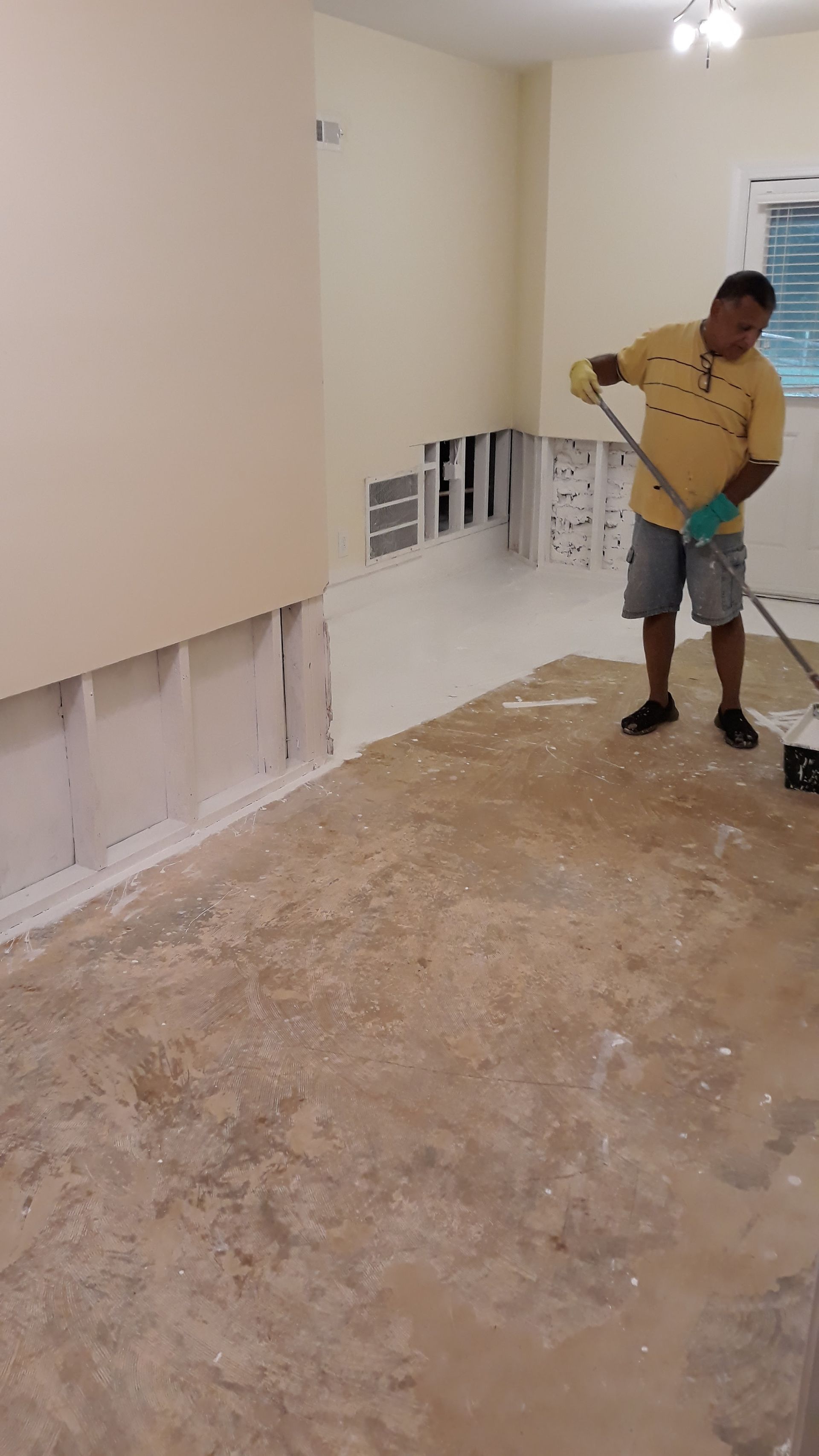 a man is standing in a room with a mop