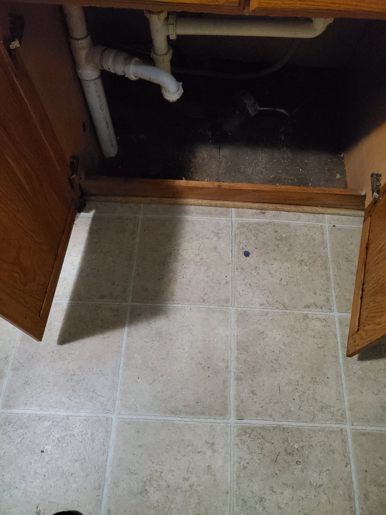 a sink is sitting under a cabinet in a bathroom