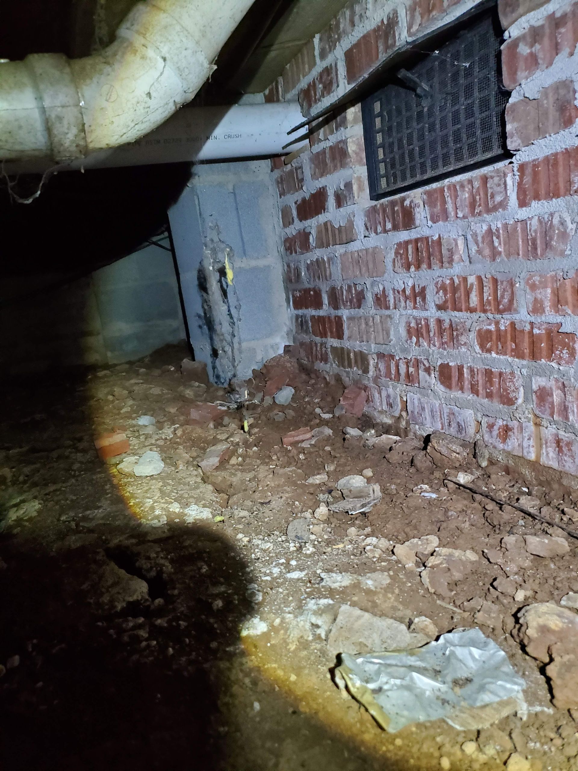 a brick wall in a basement with a pipe coming out of it.