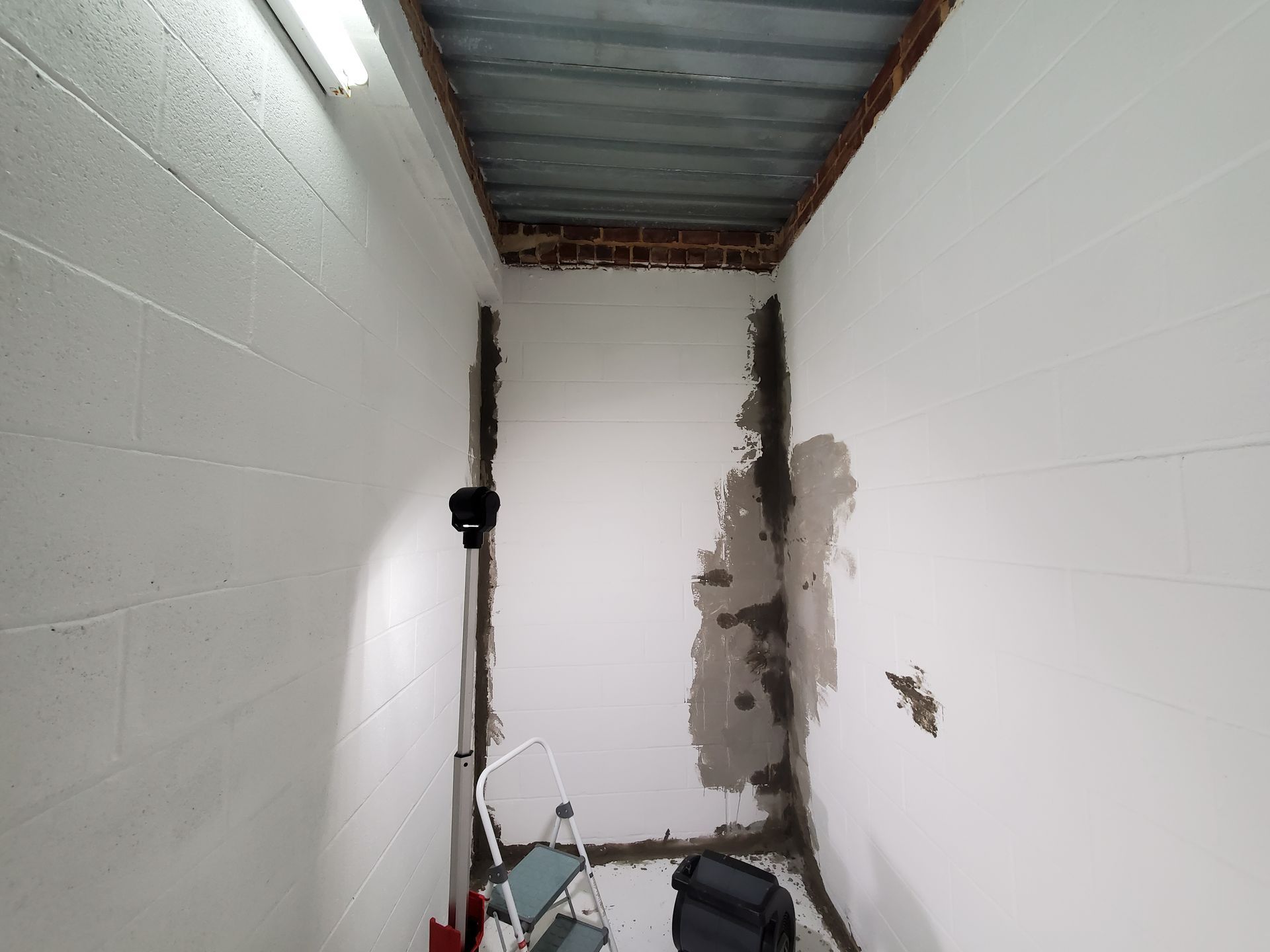 a small room with white walls and a metal ceiling