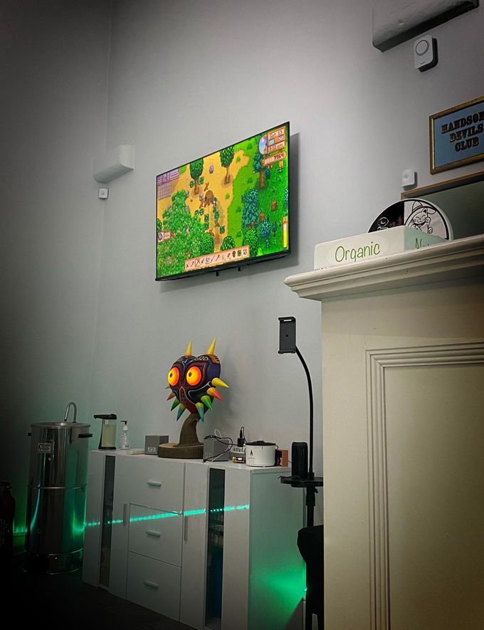 A living room with a television and a statue of a monster head.