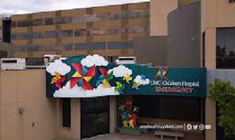 Colorful geometric mural on a building facade beside a sign reading “LCHC Children’s Hospital.”
