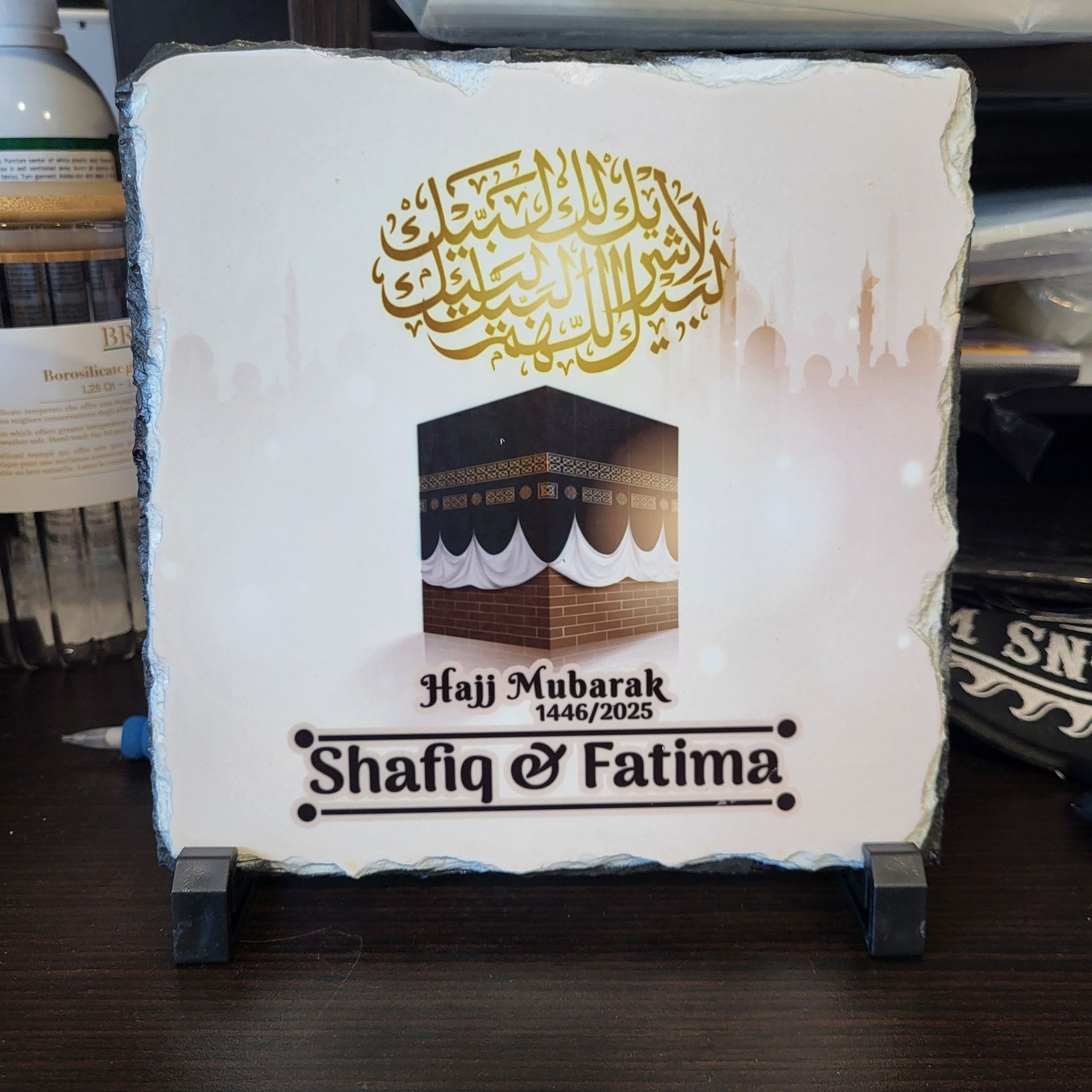 Square stone art with gold calligraphy, Kaaba illustration,