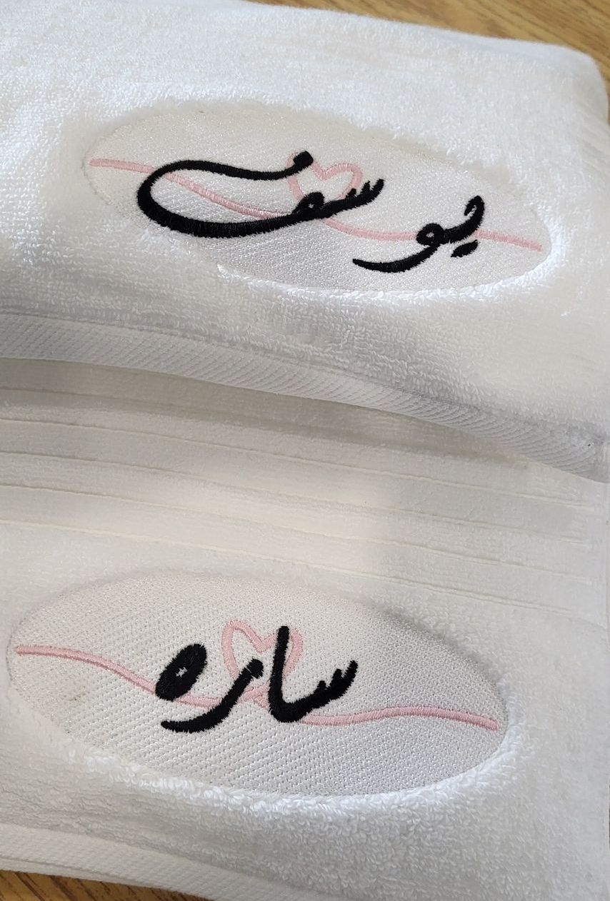 Two embroidered name tags in Arabic script: