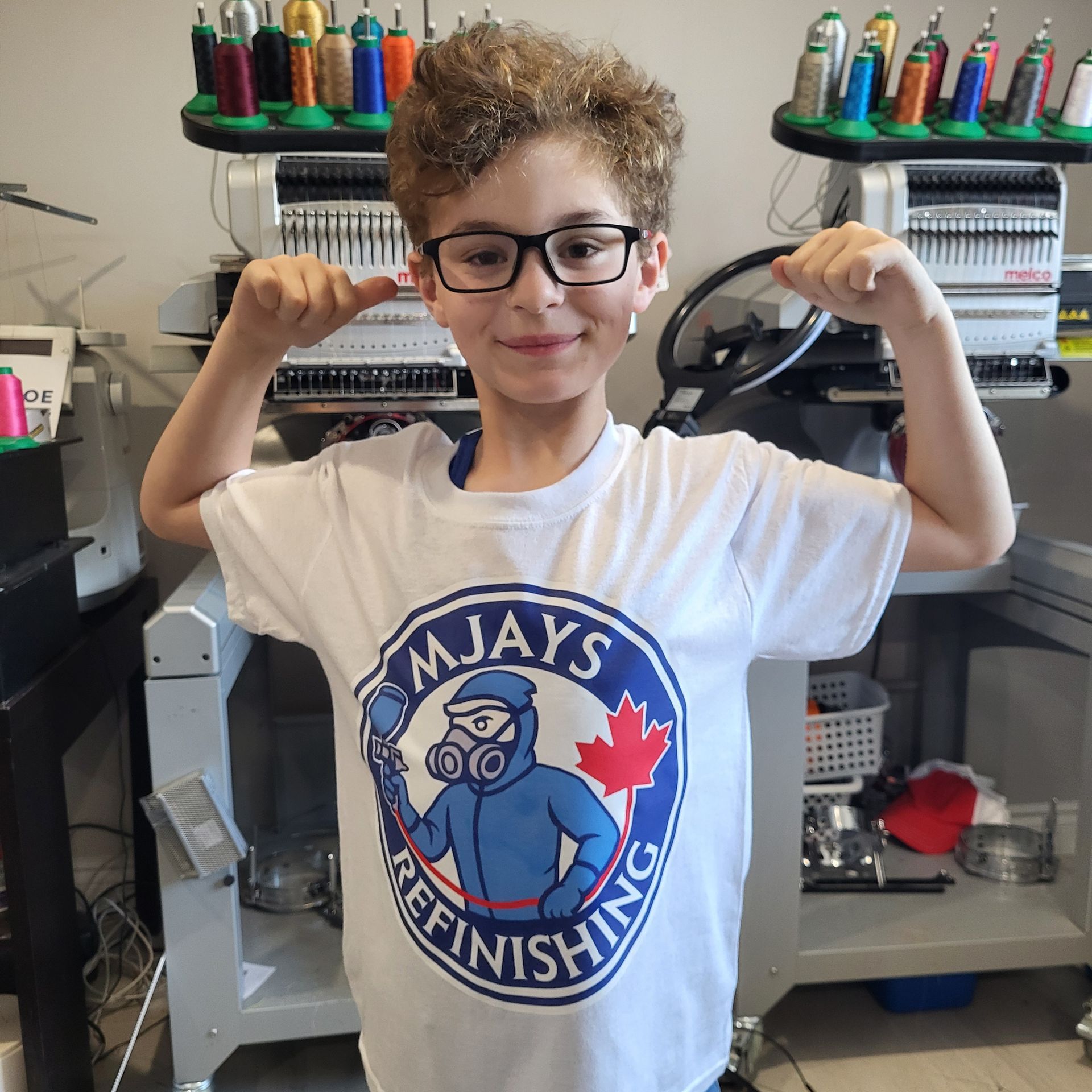 Boy flexing biceps, wearing a white shirt with