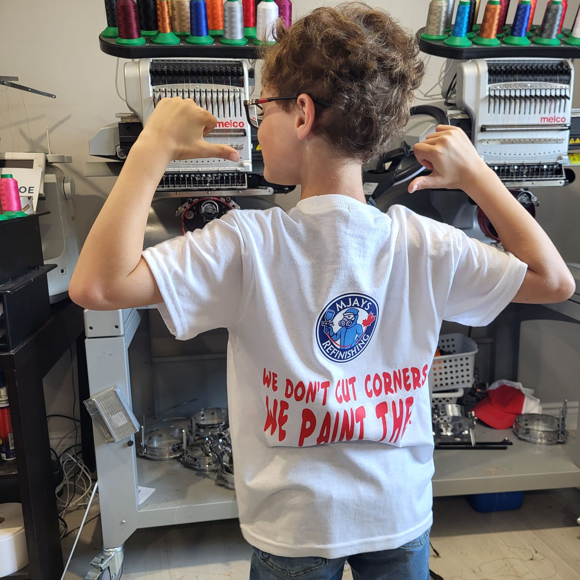 Boy flexing in white shirt with logo