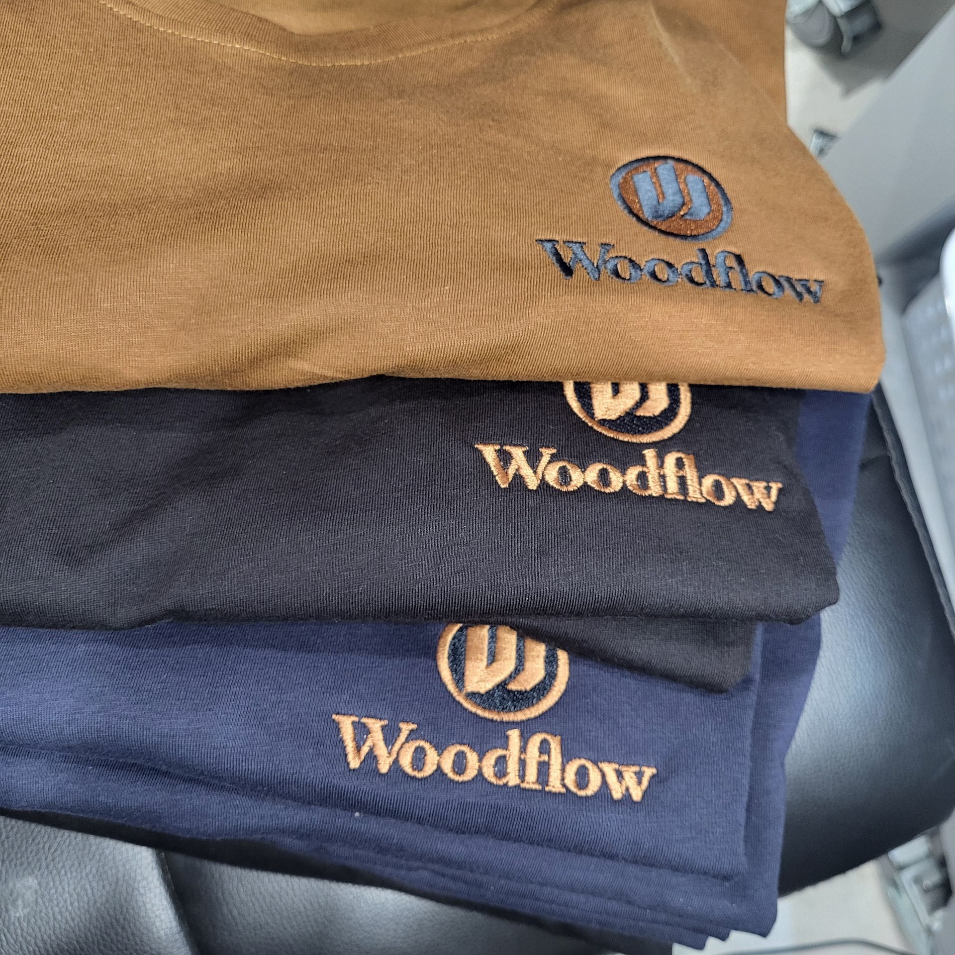 Three folded shirts with embroidered