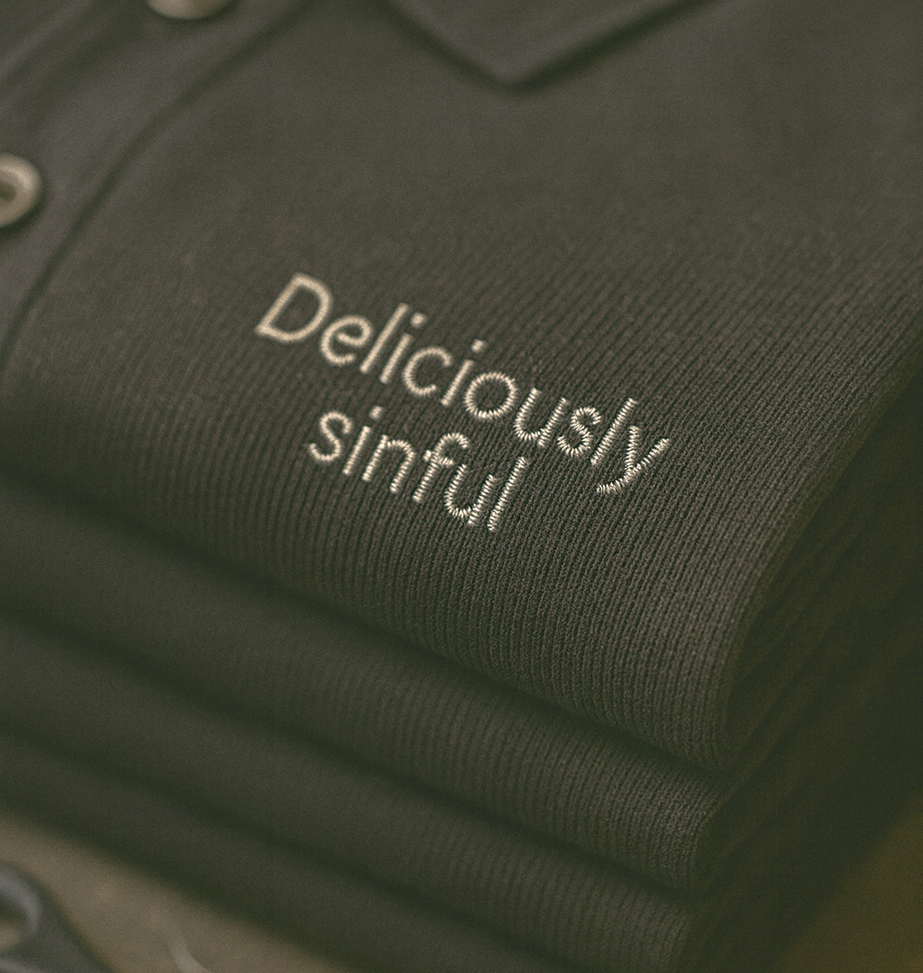 Folded black shirts with embroidered text