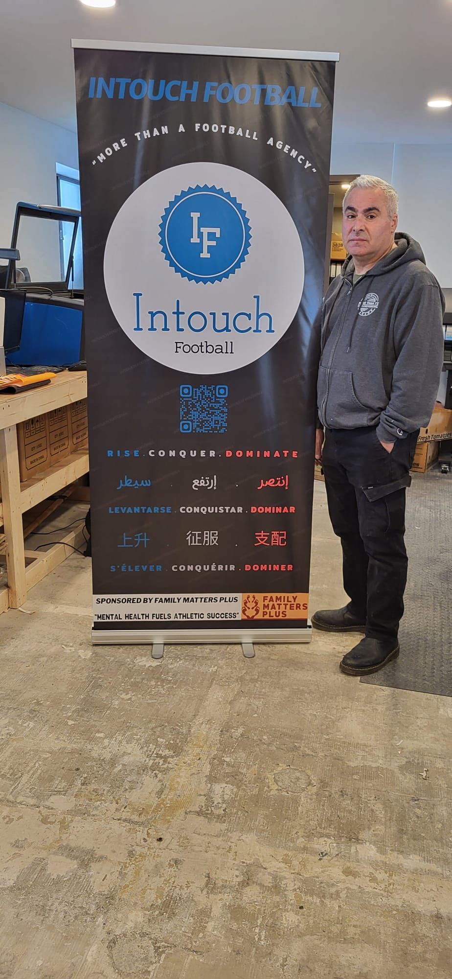 Man stands next to a banner that reads