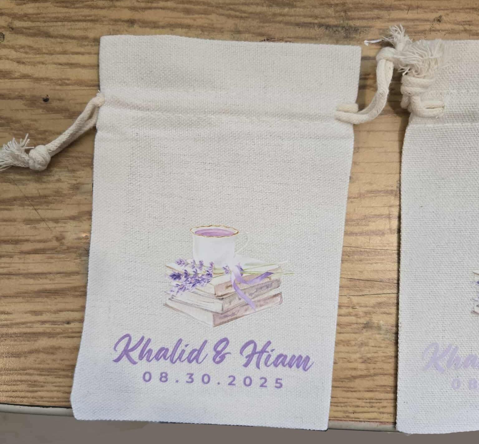 Two white favor bags with a wedding design printed in lavender. The bags say