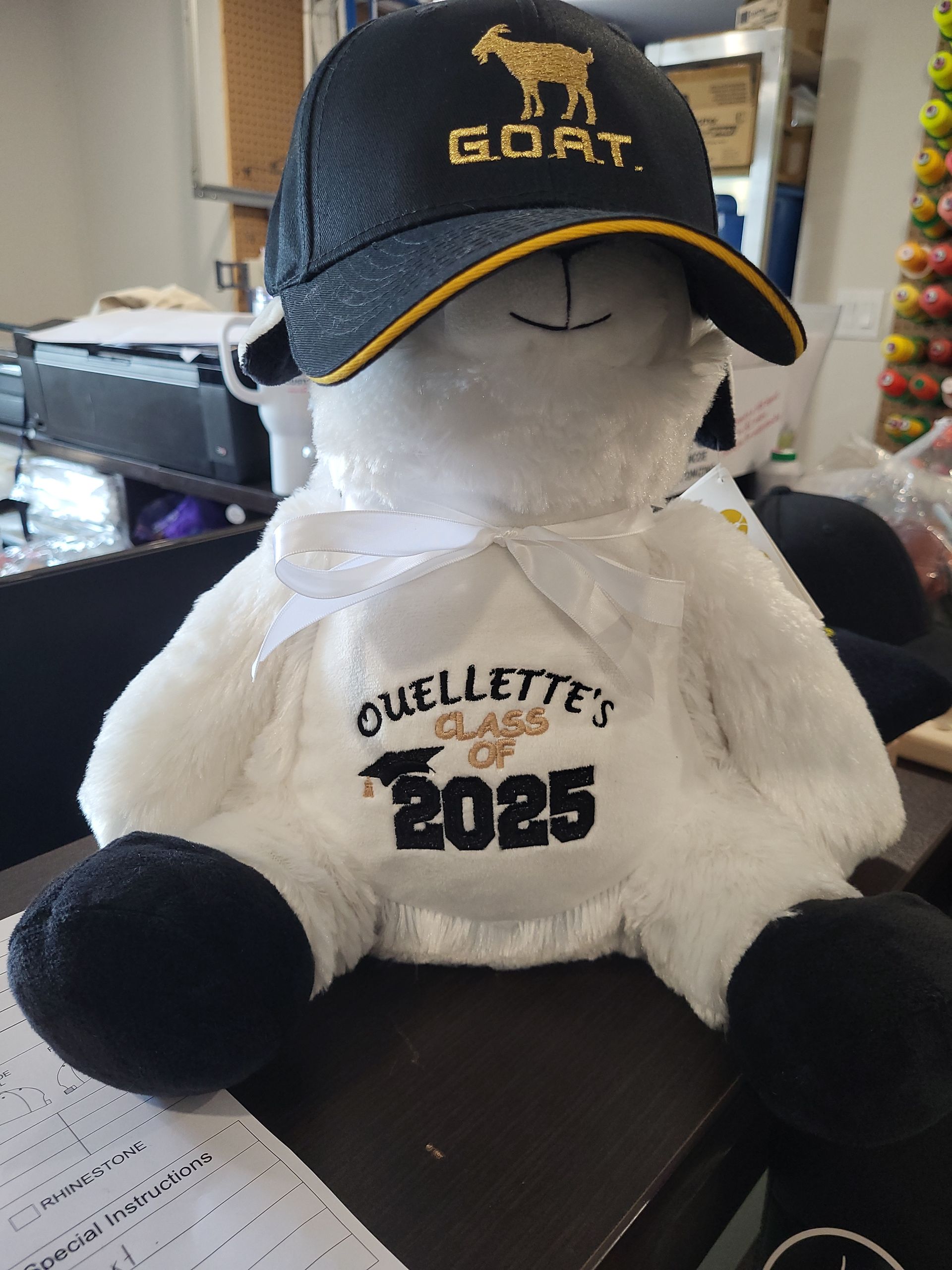 Stuffed sheep wearing a hat that says