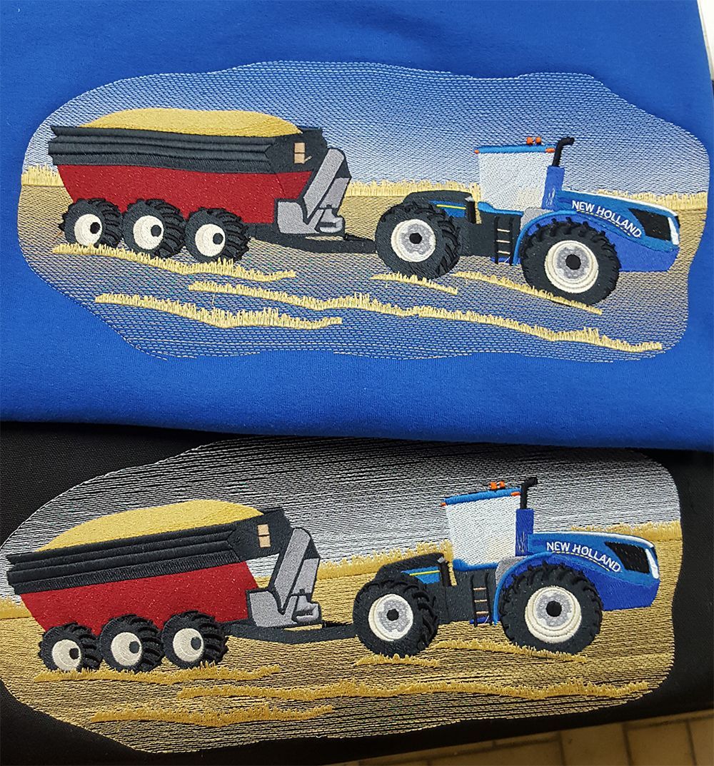 Embroidered tractors pulling grain carts, on blue and black shirts, set in a field.