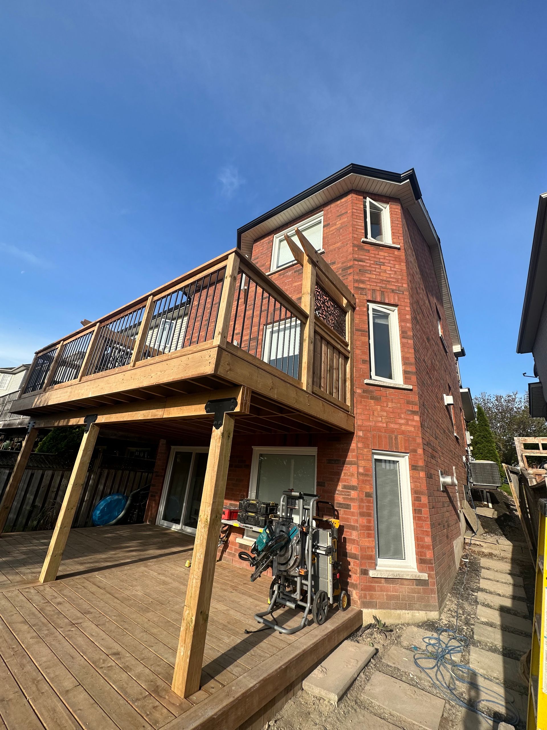 A large brick house with a wooden deck in front of it.