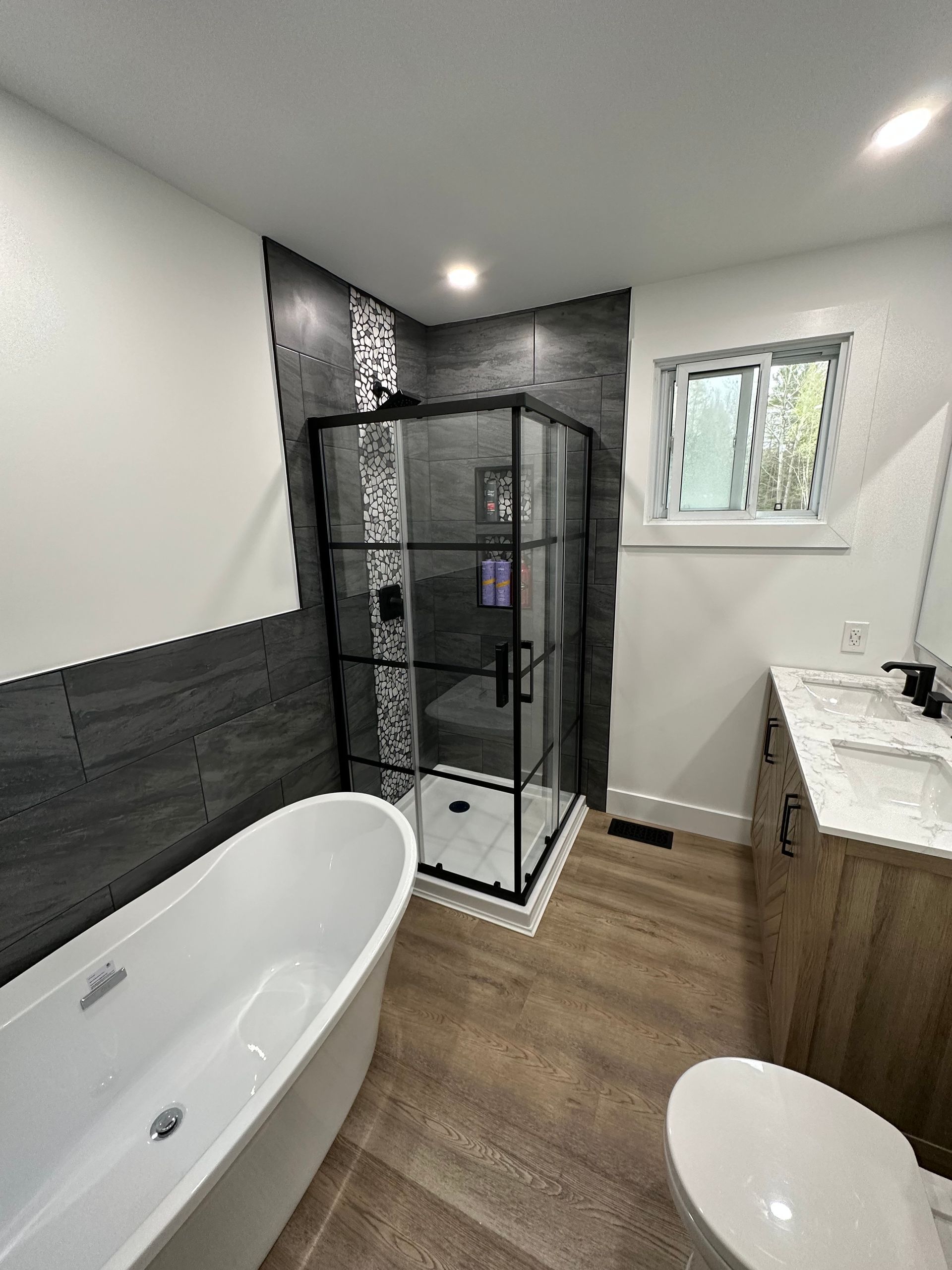 A bathroom with a tub , toilet , sink and shower.