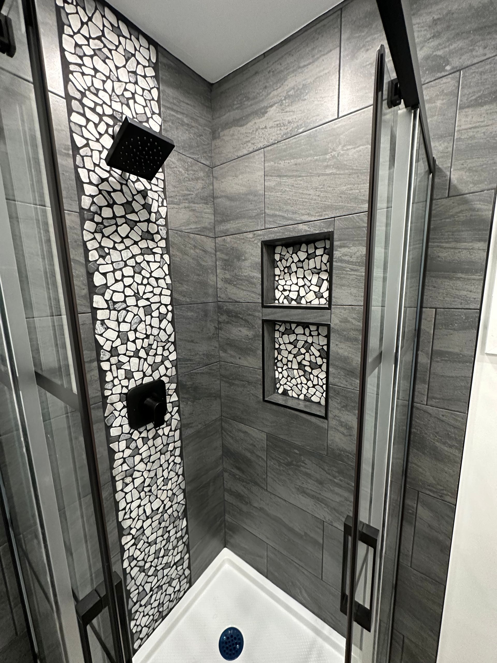 A bathroom with a walk in shower and a sliding glass door.