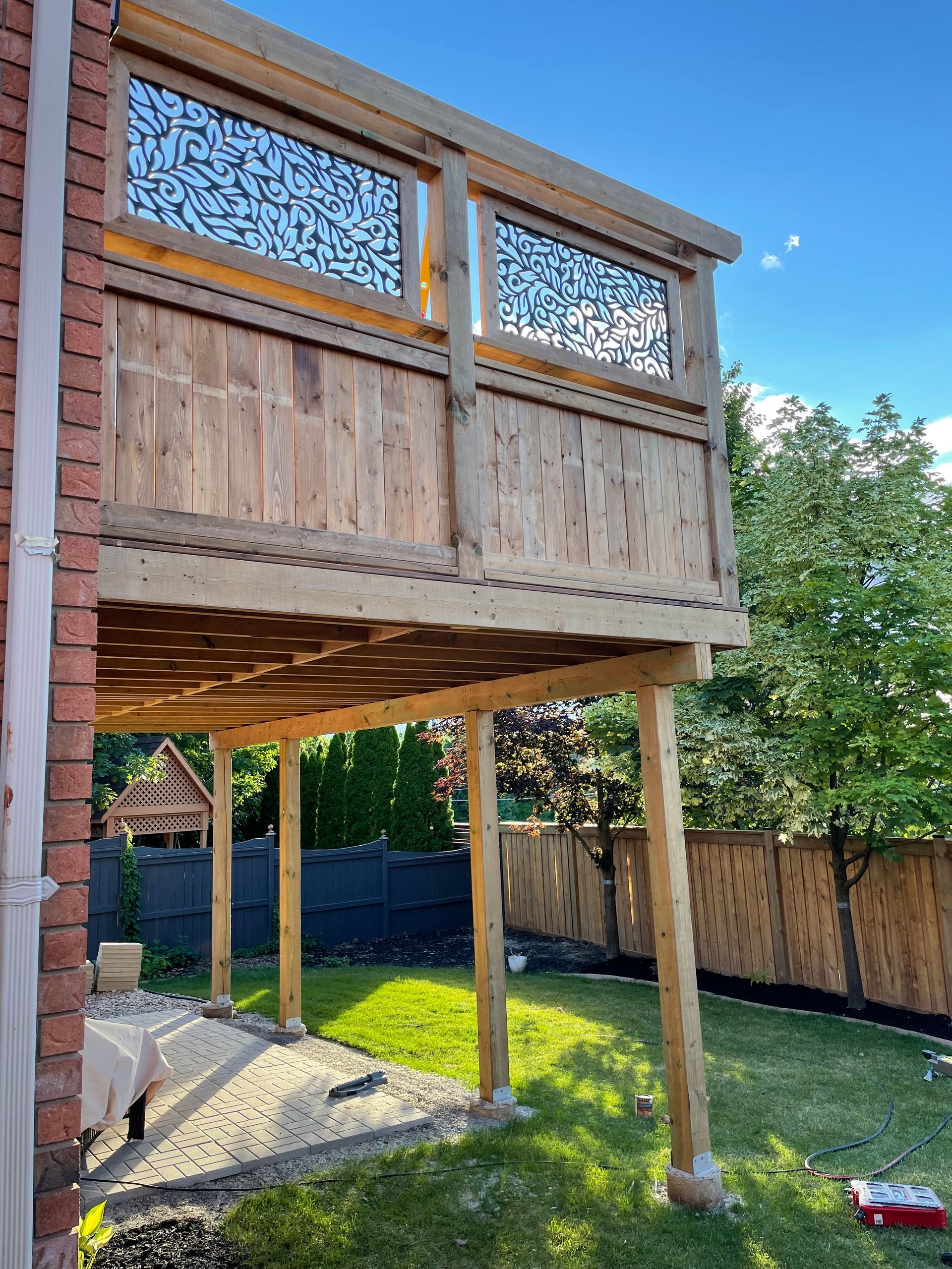 A wooden deck is being built in the backyard of a house.