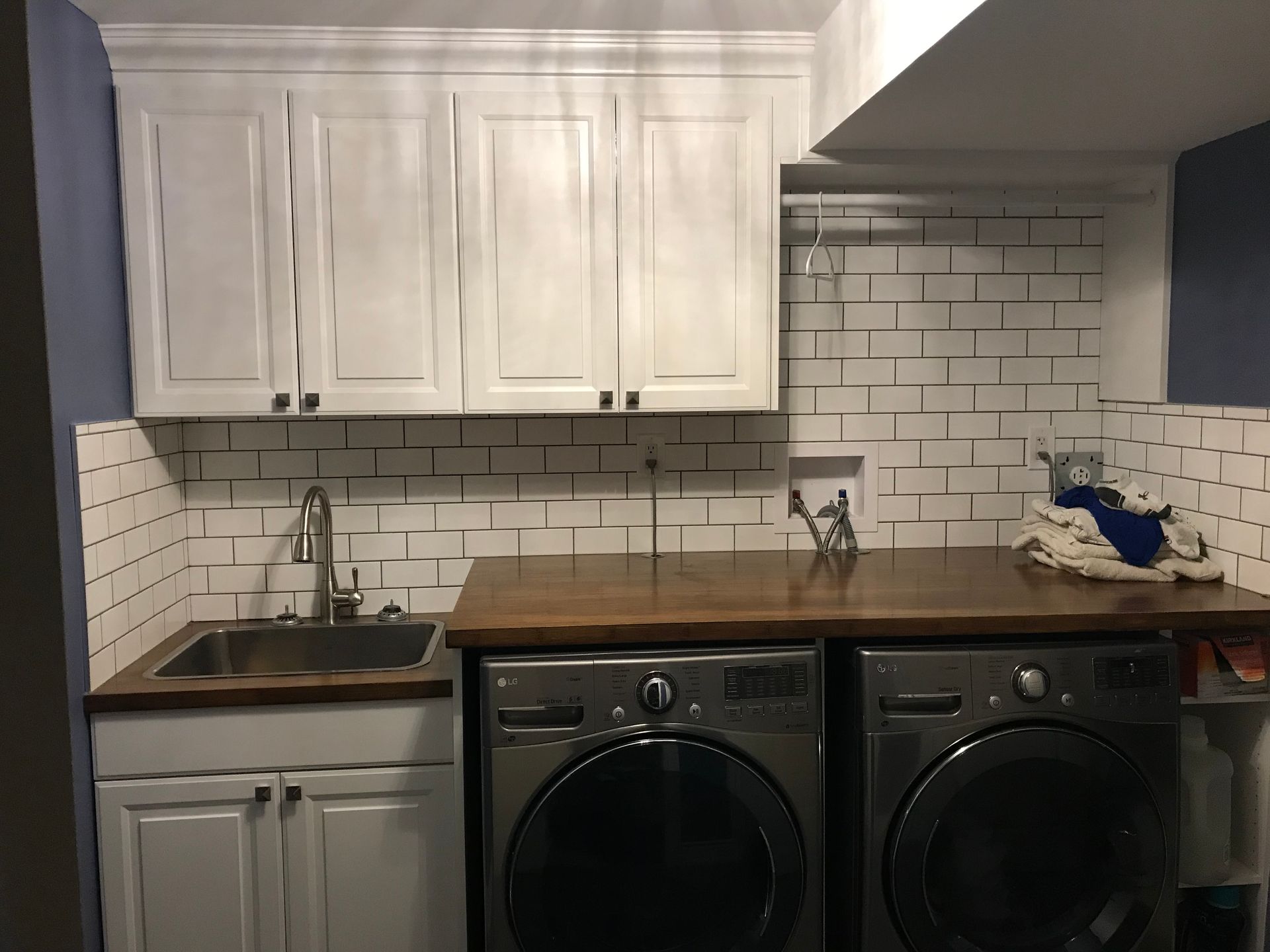A laundry room with a washer and dryer and a sink