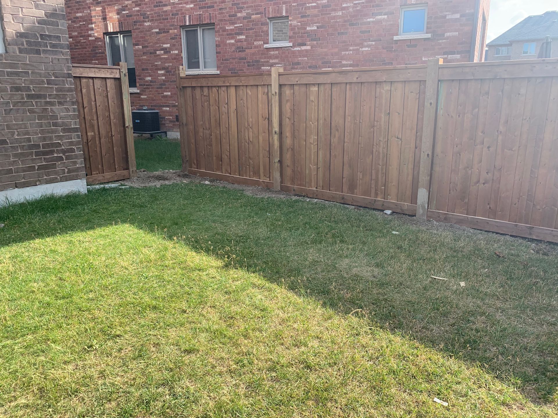There is a wooden fence in the backyard of a house.