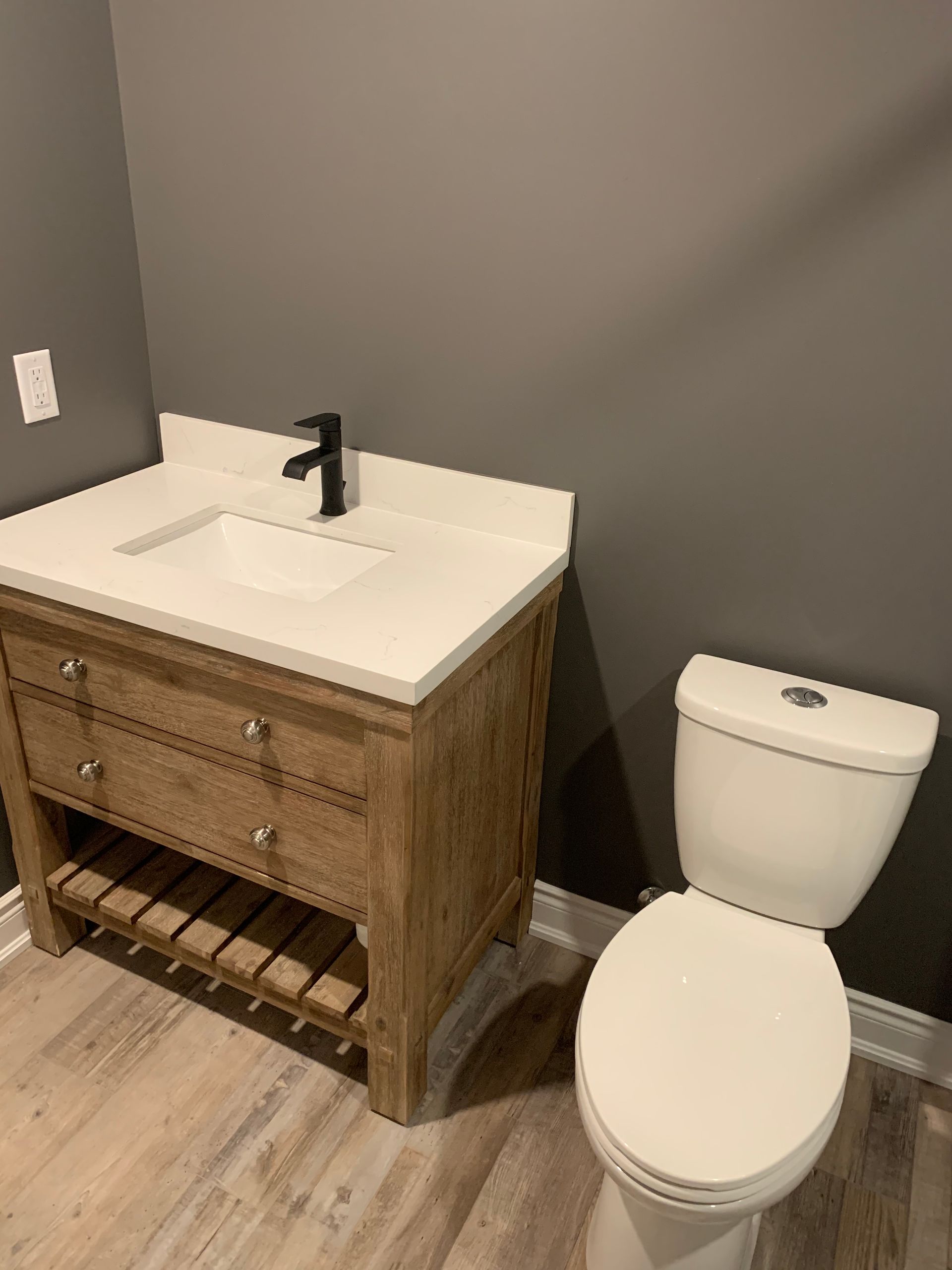 A bathroom with a sink , toilet and vanity.