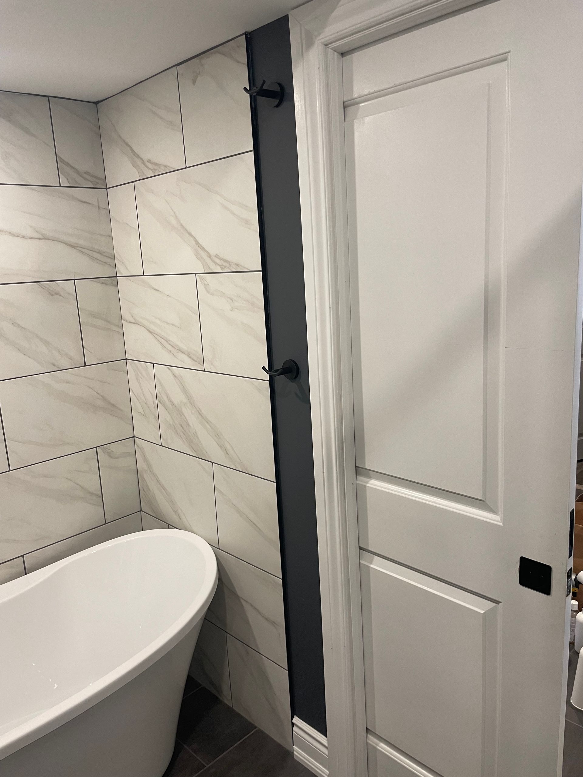 A bathroom with a bathtub and a white door