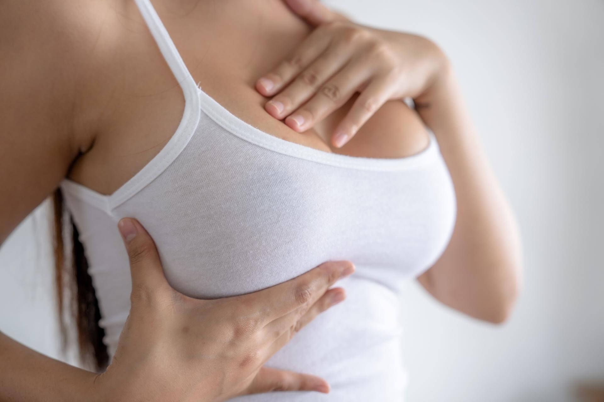 Una donna con una canottiera bianca viene visitata da un medico.