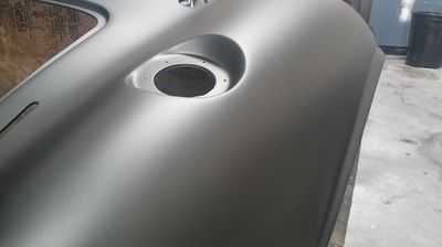 A close up of a car door with a hole in it