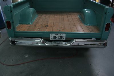 The back of a truck with a wooden floor and a texas license plate