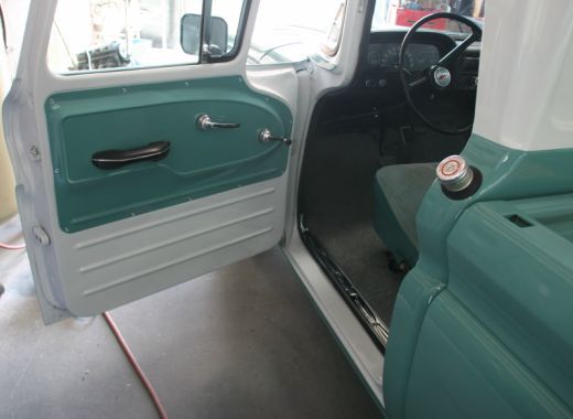 The inside of a green and white truck with the door open