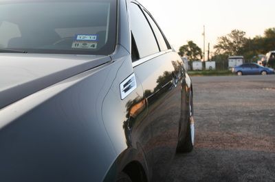 A black car is parked in a parking lot
