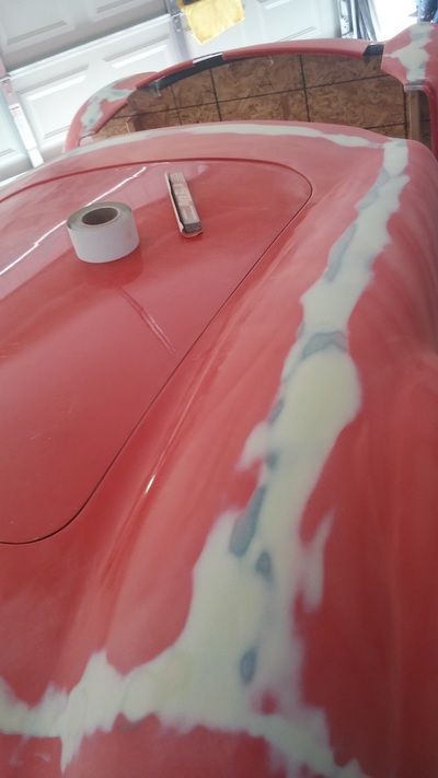 A close up of a red car with a roll of tape on top of it